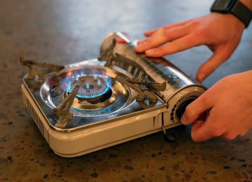 A man uses a gas camping stove