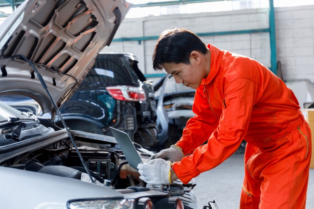 A driver support engineer works on an engine