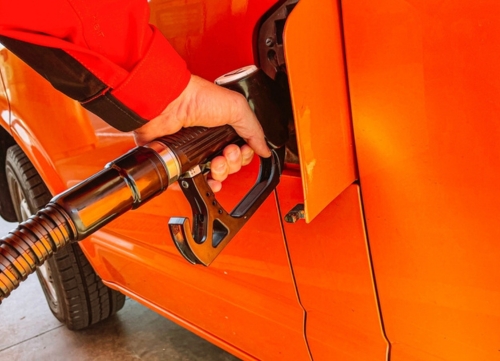 a hand fuels up an orange van